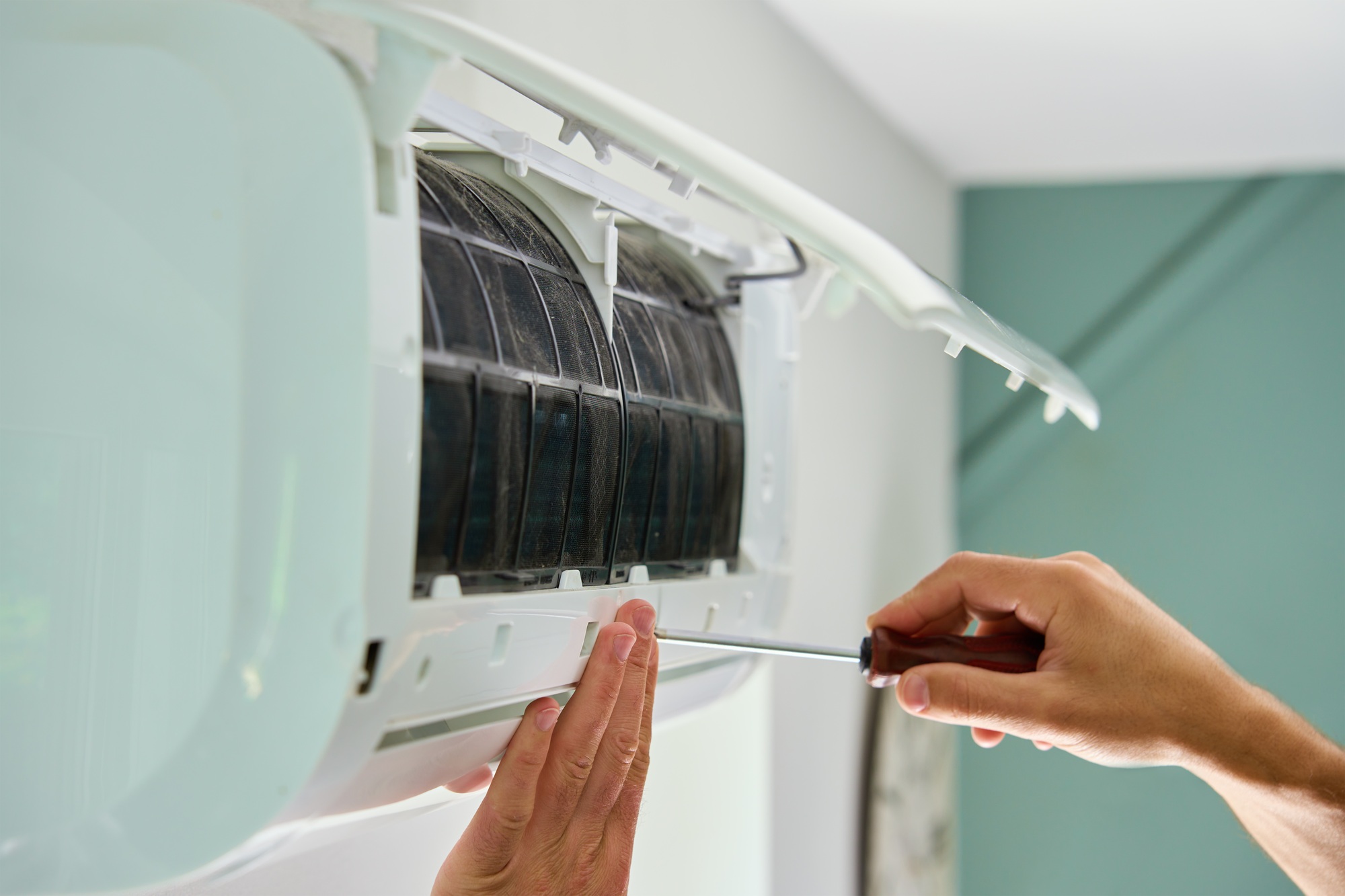 Air conditioner maintenance. Male technician repairing cooling system